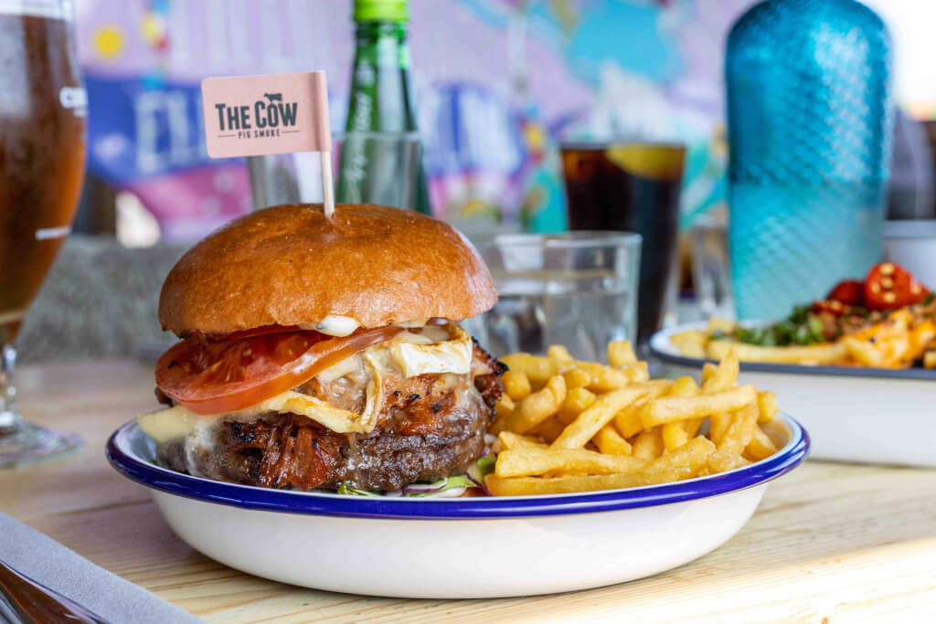 A photo of a cheeseburger and chips from The Cow restaraunt